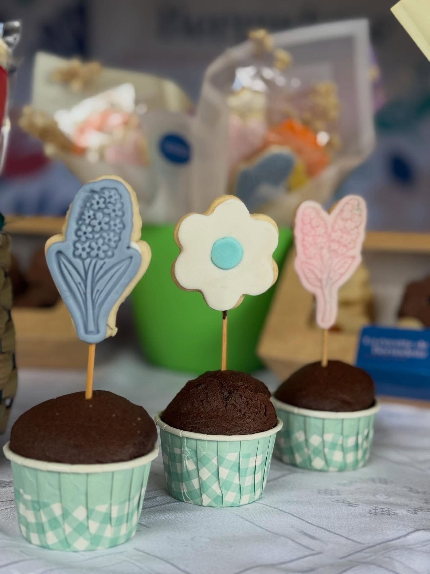Chocolate cupcakes topped with hand-iced flower cookies